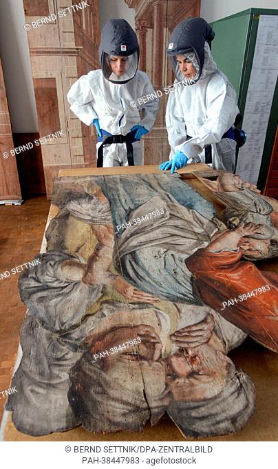 Restaurators in protective suits against chemicals examine parts of the Neuzelle Passion Depiction at the state office for the preservation of monuments in...