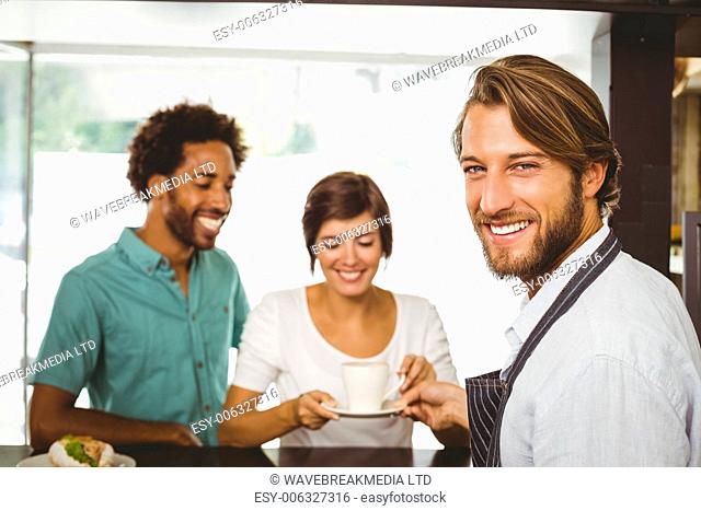 Barista talking with two customers at the coffee shop