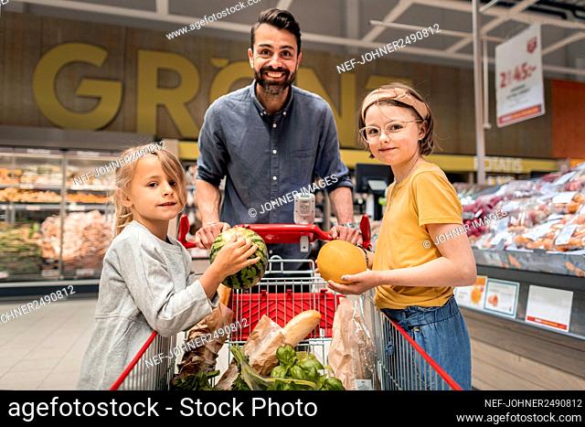 Father with daughters doing shopping in supermarket