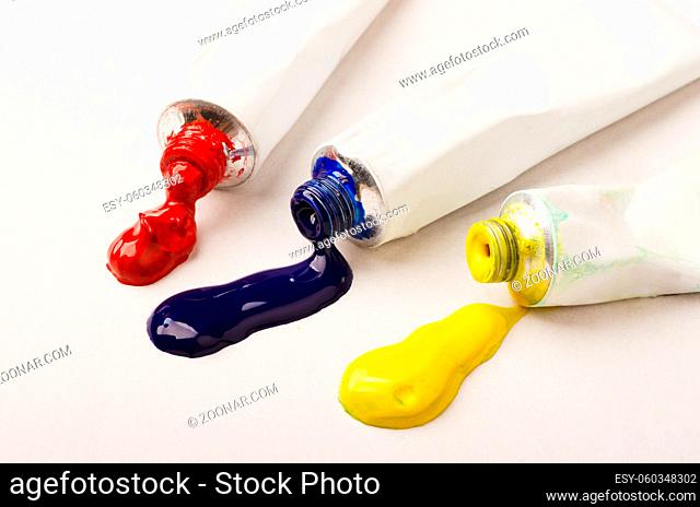Tubes of three red, blue and yellow paint on a white background