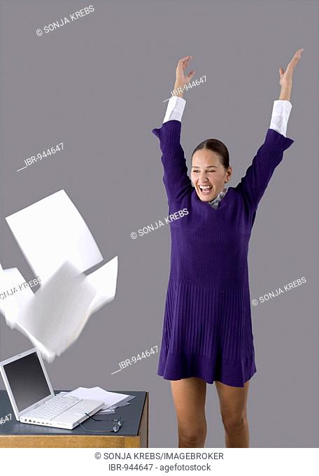 Young woman throwing sheets of paper around