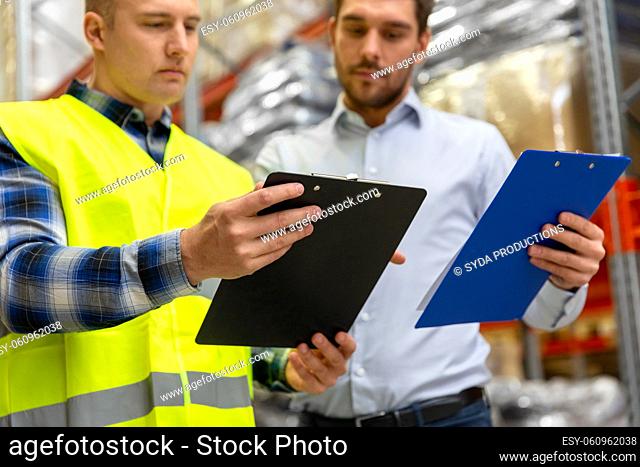 worker and businessman with clipboard at warehouse