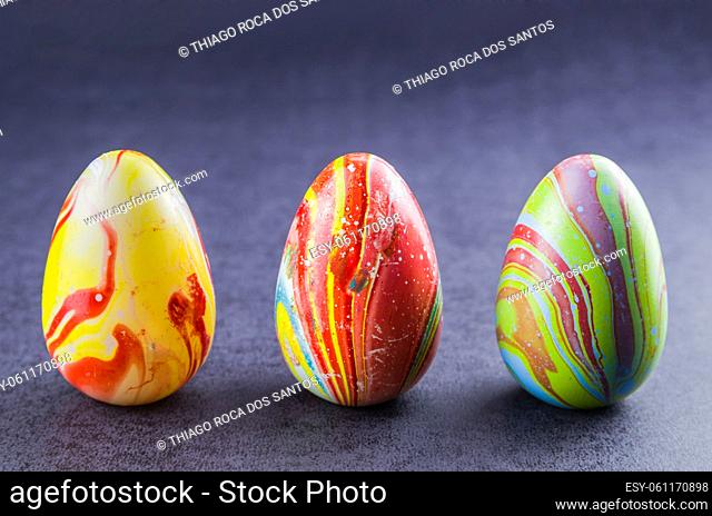 Colorful Easter eggs lined up side by side on a trendy black background