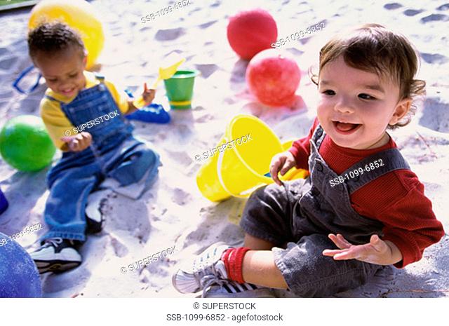 High angle view of two boys playing in the sand