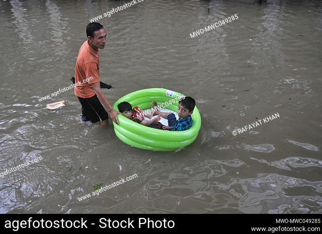 Sylhet, Bangladesh. 20th June 2022. Children float in a blown up tub through flood water as they look for shelter amidst heavy rains