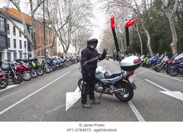 A biker standing in front of his motorcycle salutes to take a picture dressed as a devil. 37th Edition of PINGÜINOS. Concentration of motorcyclists