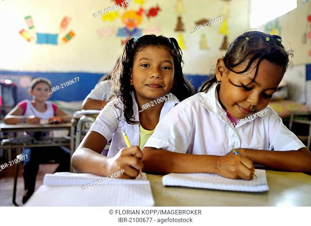 Two girls sharing a bench at school, school in Las Mesitas, Bajo Lempa, El Salvador, Central America, Latin America