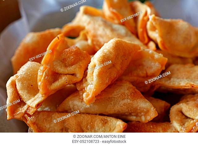 Close up portion of traditional Chinese Jiaozi deep fried dumplings on paper, high angle view