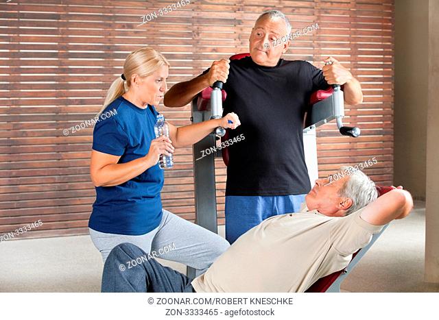 Drei Senioren reden während einer Trainingspause im Fitnesscenter miteinander