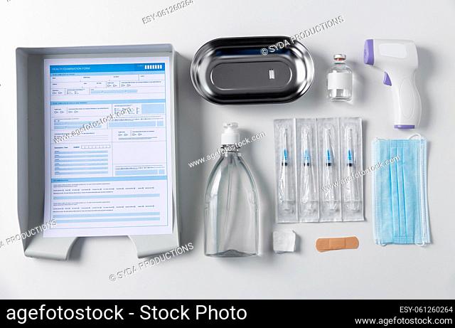 syringes, mask, sanitizer and other stuff on table