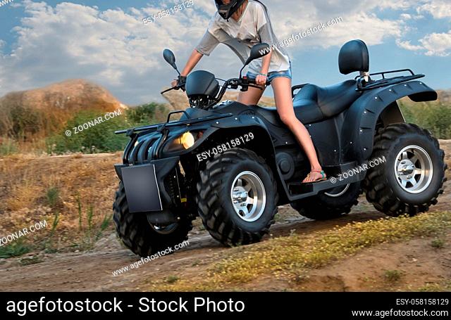 quad bike on a dirt road (all logos, inscriptions and markings removed)