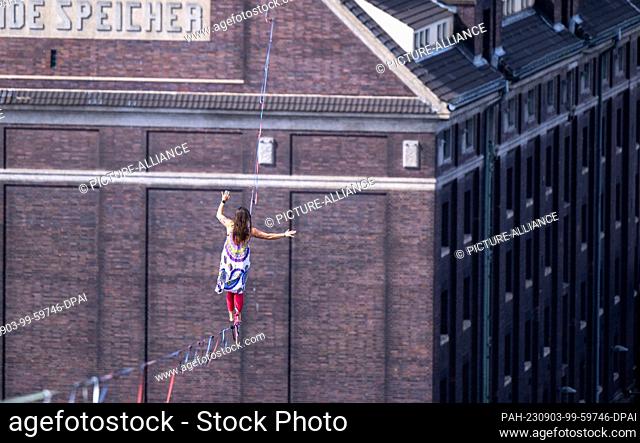 03 September 2023, Berlin: Rope acrobat Kasia balances on a high wire stretched between two towers at the celebration of the 100th anniversary of Berlin's...