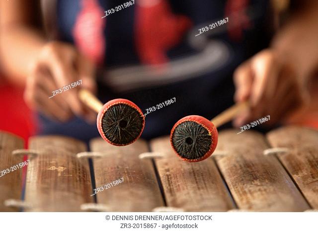 A young woman practices playing a traditional Cambodian xylophone in Phnom Penh, Cambodia