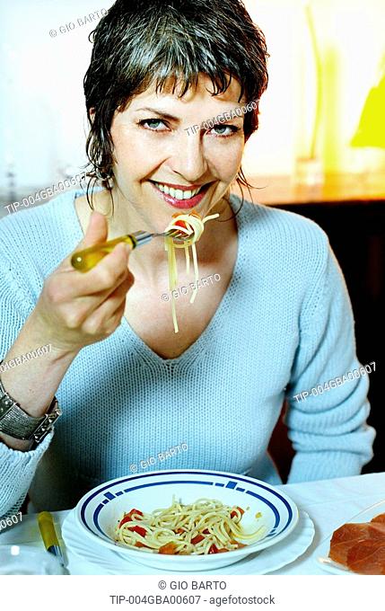 Woman over forty eating pasta
