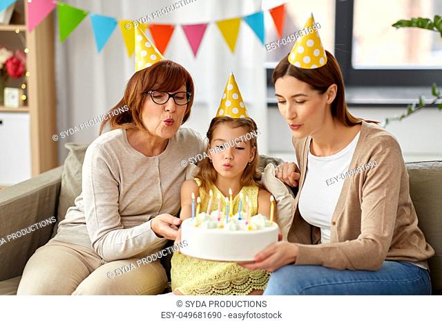 mother, daughter, grandmother with birthday cake