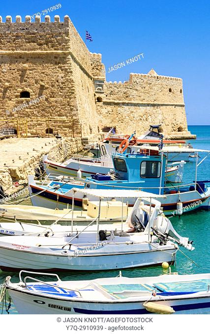 Fishing boats moored in the inner harbour with the Koules Fortress in the background, Heraklion, Crete, Greece