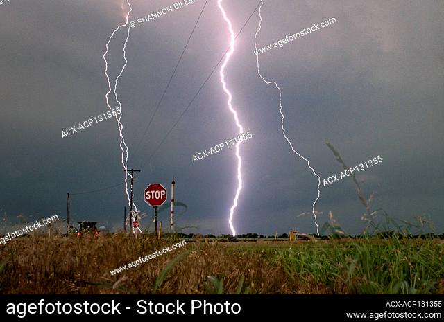 Storm with lightning strikes over a rural field in Oklahoma United States 4 image merge incliuding a lightning strike hitting a power pole