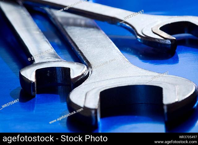 Industrial metal spanner tools on a blue background