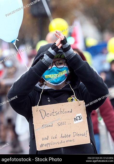 20 October 2020, North Rhine-Westphalia, Dortmund: A participant in a strike rally hung a cardboard sign around her neck saying ""Germany stood still
