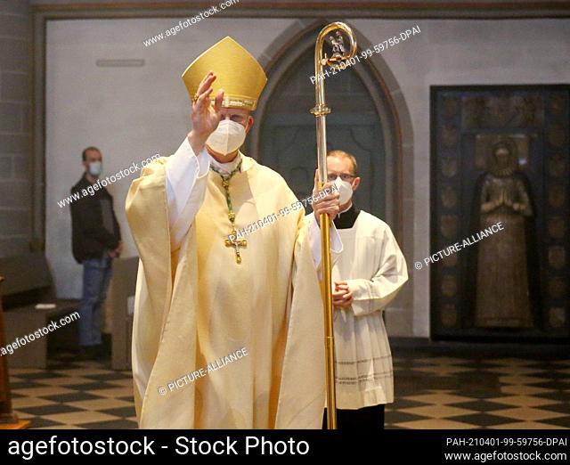01 April 2021, North Rhine-Westphalia, Essen: Bishop Josef Overbeck enters the cathedral with the altar servers. The bishop celebrates the Pontifical Mass