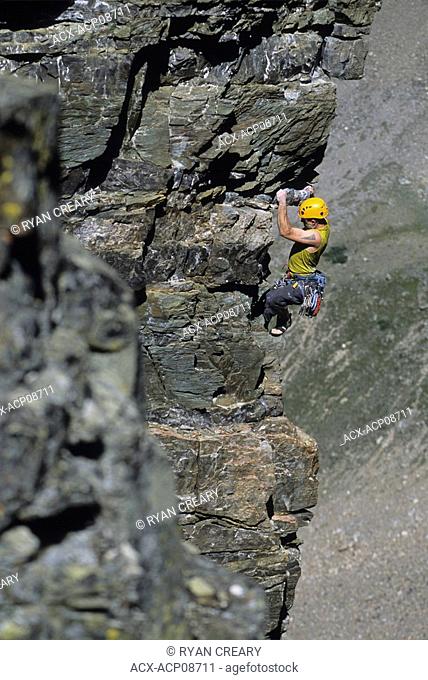 A young man climbing the Cardiac Arete on the Grand Sentinel, Alberta, Canada