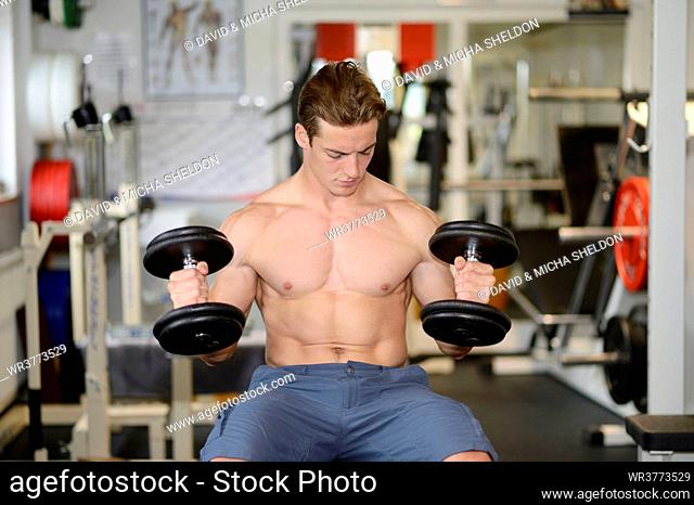 Young man exercising in fitness center