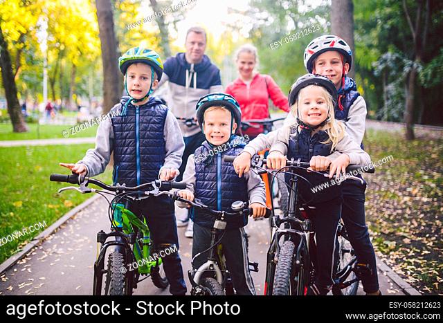 Theme family sports vacation in park in nature. big friendly Caucasian family of six people mountain bike riding in forest