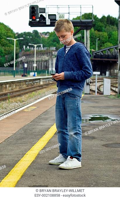 youth texting at railway station