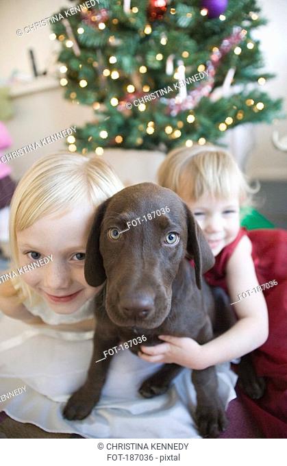Two young girls at Christmas with brown dog