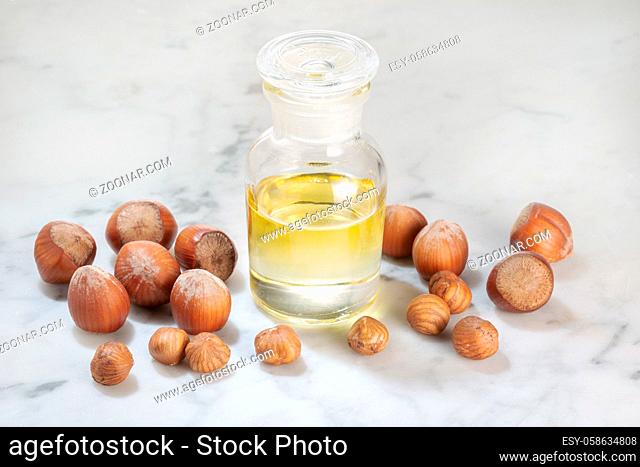 Hazelnut oil in glass bottle on marble table. Oil for Cosmetic or beauty care