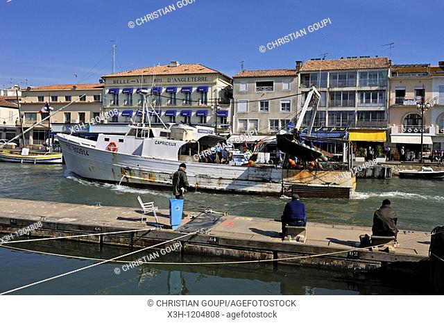 fishermen in the port of Grau du Roi, with background the Bellevue hotel where Ernest Hemingway stay in 1949, Gard department, Languedoc-Roussillon region