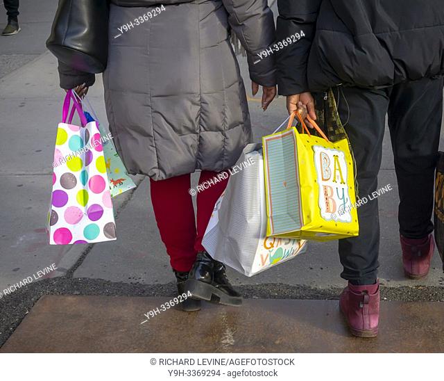 Shoppers carry shopping bags with child-oriented themes in New York on Thursday, February 14, 2019. (© Richard B. Levine)