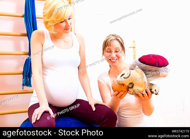 Midwife giving pregnant woman antenatal care for childbirth in practice