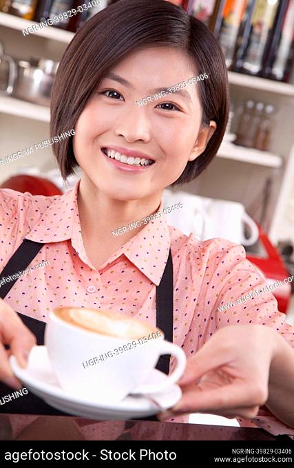 Portrait of barista serving coffee