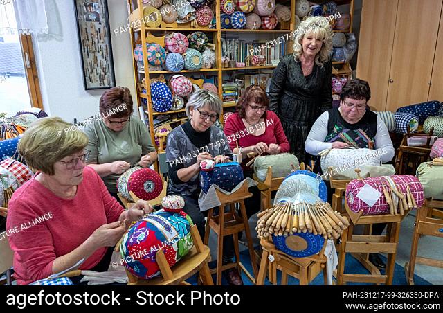 PRODUCTION - 21 November 2023, Saxony, Annaberg-Buchholz: At the lace-making school in Annaberg-Buchholz, lace-making teacher Manuela Fischer stands between her...