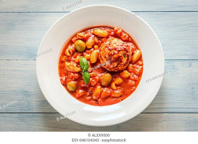 Portion of minestrone soup with meatball