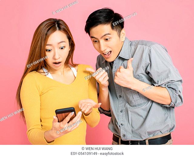 Shocked young couple watching the smart phone