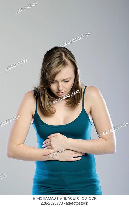 Young woman hands on aching belly