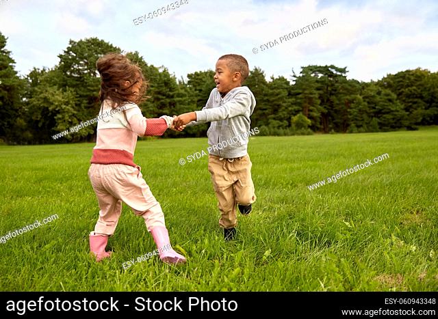 happy little boy and girl having fun at park