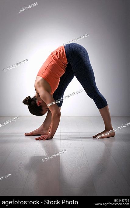 Sporty fit woman stretching in Ashtanga Vinyasa yoga asana Parsvottanasana, intense side stretch pose