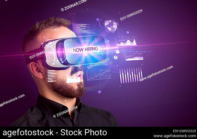 Businessman looking through Virtual Reality glasses with NOW HIRING inscription, new business concept