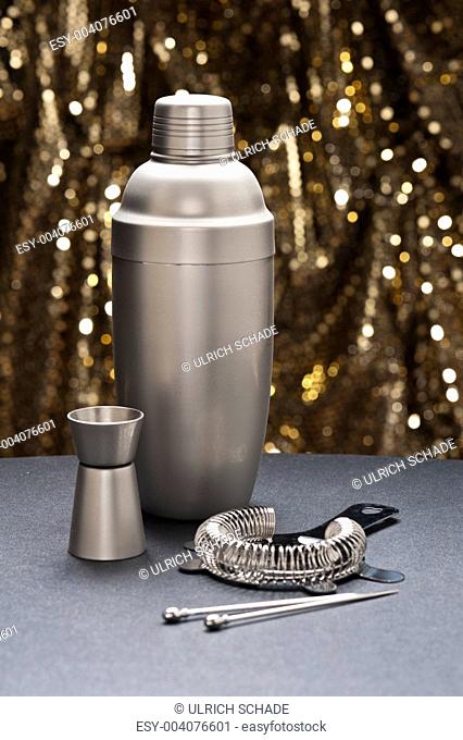 Bartender tools in front of a gold glitter background