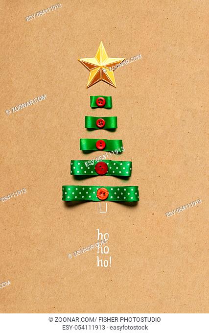 Creative concept photo of christmas tree made of ribbon on brown background