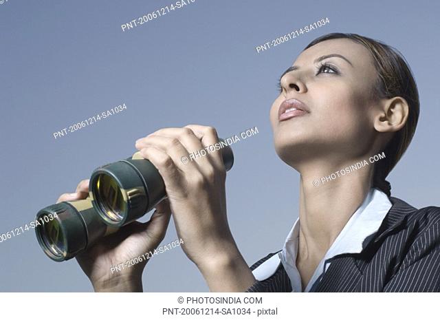 Close-up of a businesswoman holding a pair of binoculars