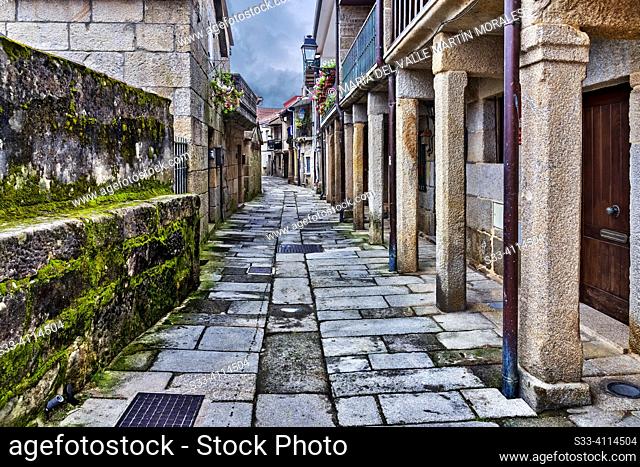 Typical alley in Combarro. Pontevedra. Galicia. The narrow, cobbled streets of Combarro are one of the charms of this picturesque fishing village in the...