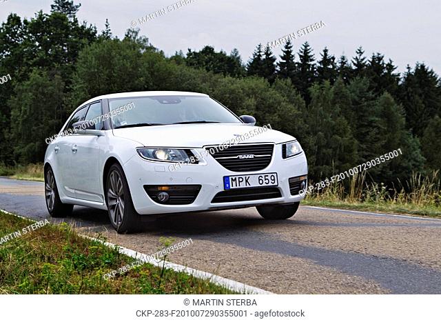 The first car Saab 9-5 Vector TiD4 Sedan in Czech Republic, a new luxury limousine of Swedish carmaker Saab, speeds up the hill on road near Czech town...