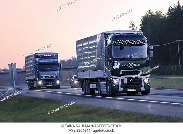 Salo, Finland - November 17, 18: Russian lorries of Arco Tours, Renault Trucks T with soccer theme and Volvo FH haul goods at sunset time in Finland
