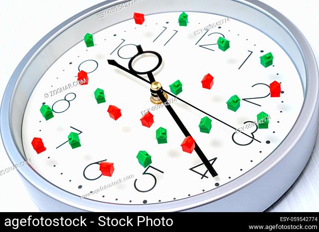 Clock face with small houses. Time to invest to real-estate