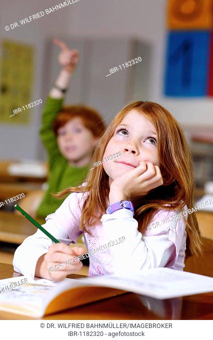 Children in a classroom in primary school, girl looking clever, cunning and knowledgable, equal oppurtunity in the education system