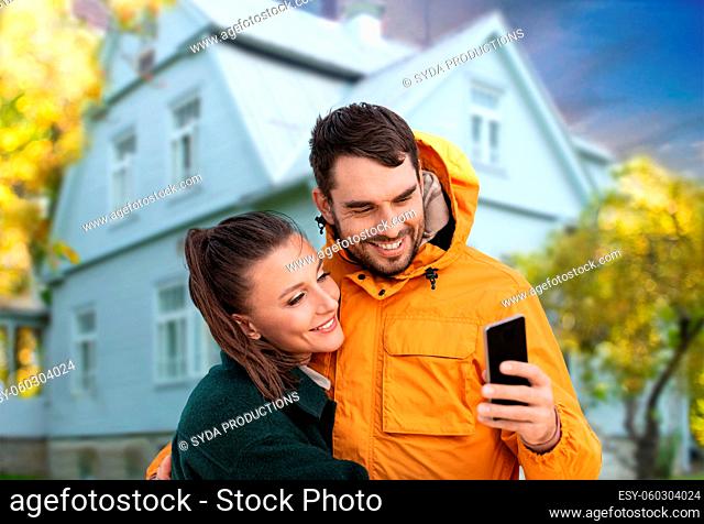 couple taking selfie over house in autumn